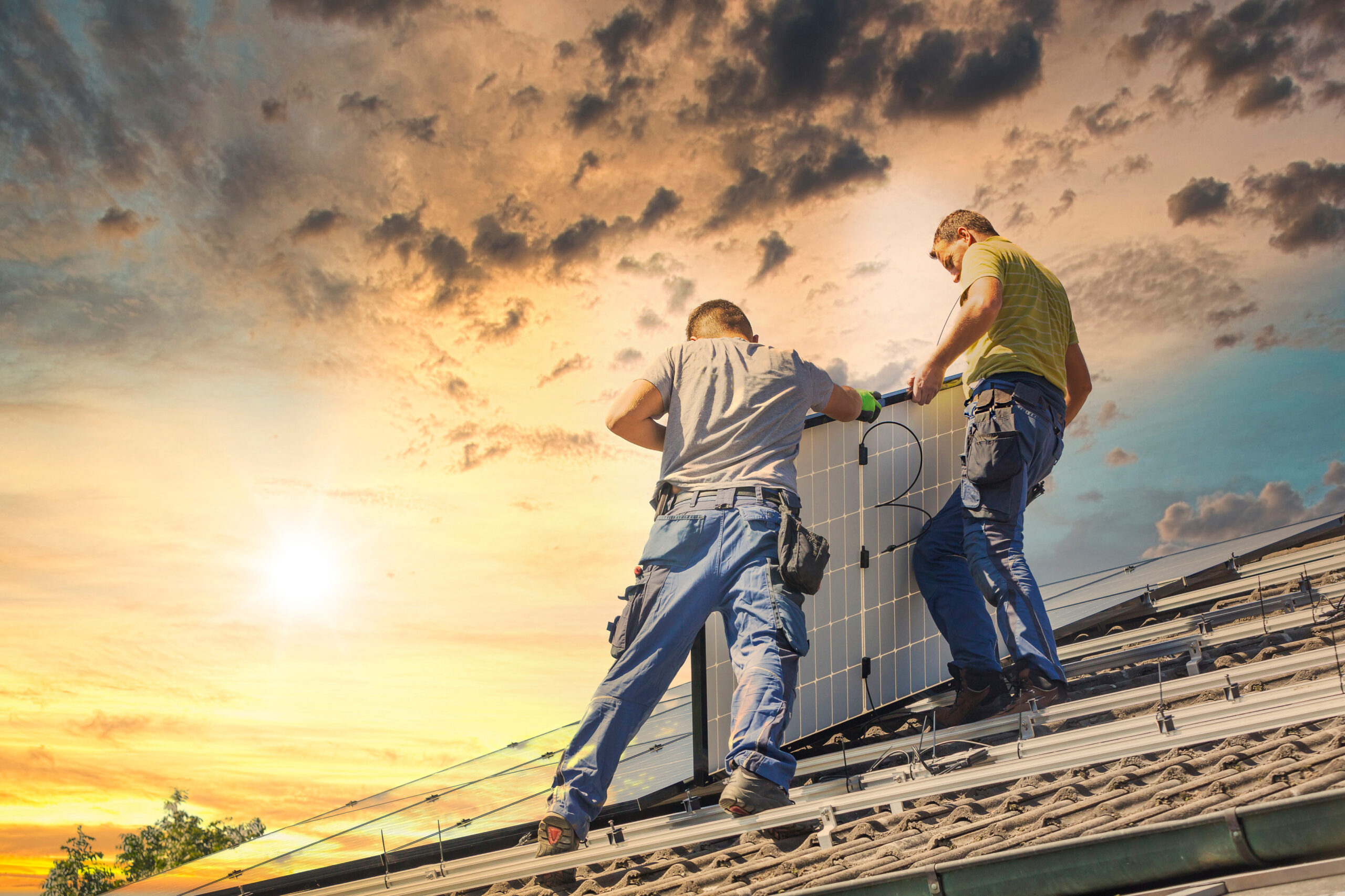 Installing solar photovoltaic panel system. Solar panel technician installing solar panels on roof. Alternative energy ecological concept.